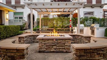 A patio with a fire pit and a pergola.